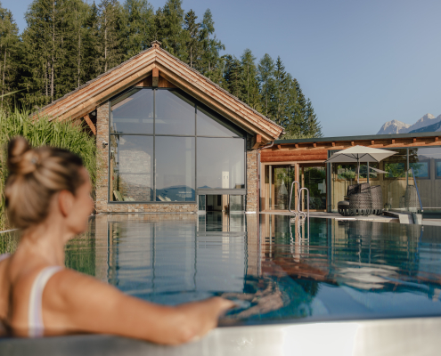 Frau im Pool mit Blick auf Berge